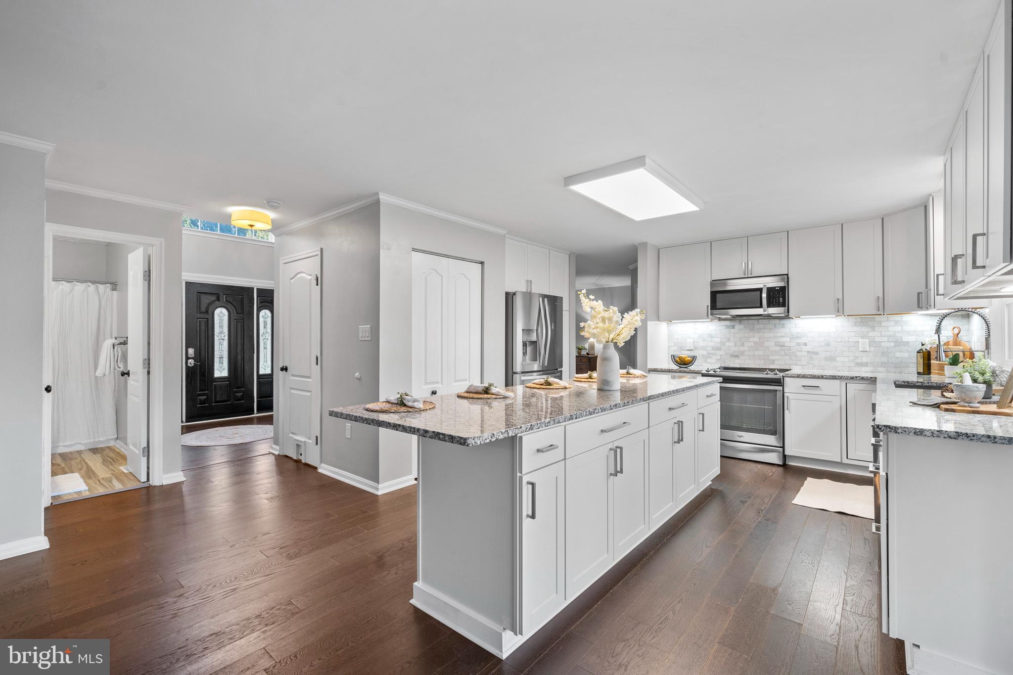 3446 Chaneyville Road Owings, MD 20736 - Photo 22 of 74 a large kitchen with stainless steel appliances lots of counter space and wooden floor