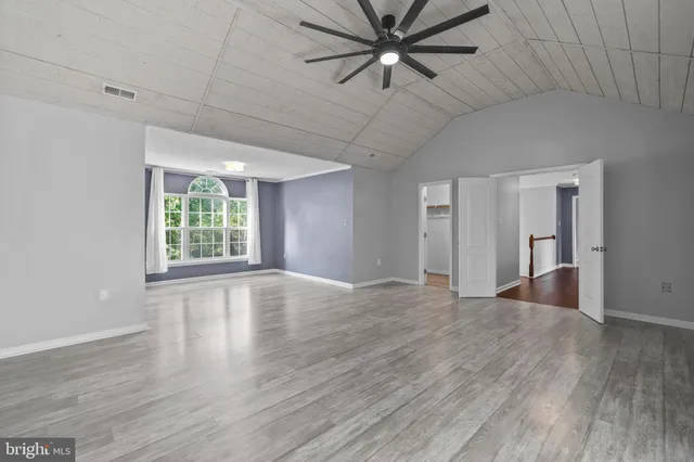 an empty room with closet and a chandelier fan