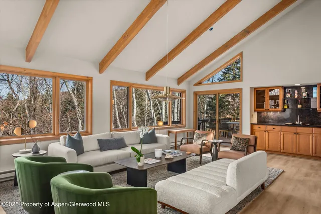 a living room with furniture kitchen view and a large window