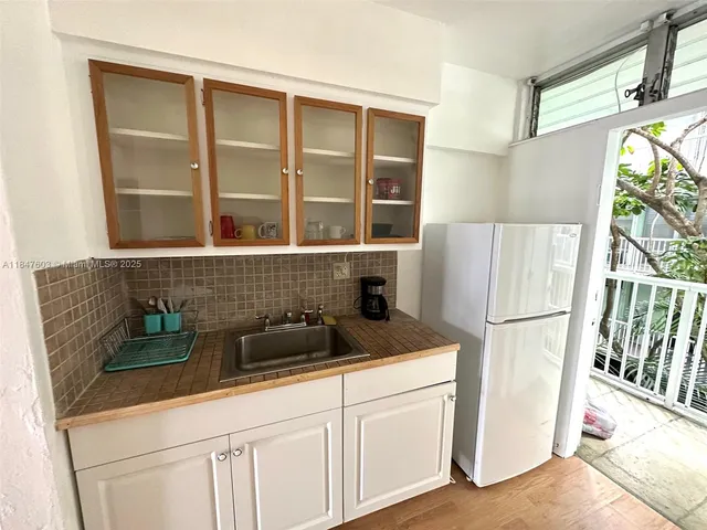 a kitchen with a refrigerator and a sink