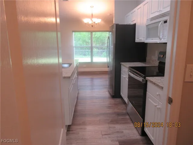 a kitchen with granite countertop a refrigerator and a stove