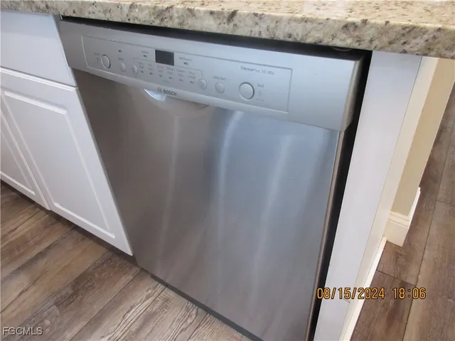 an empty room with wooden floor and windows with curtains