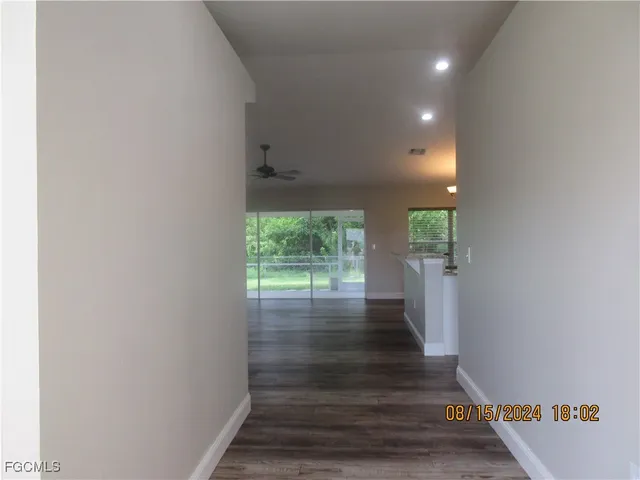 a view of a hallway with wooden floor and a floor to ceiling window