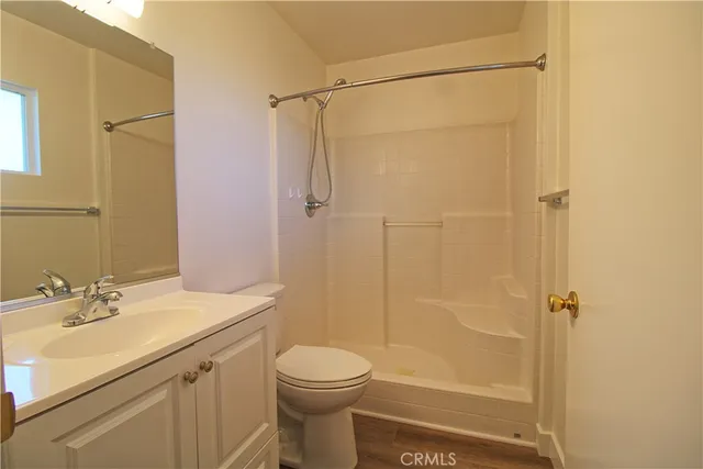 a bathroom with a shower a sink a toilet and a mirror