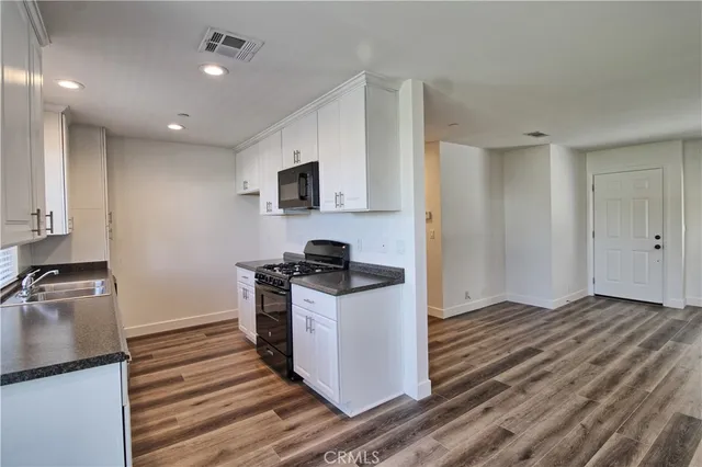 a kitchen with stainless steel appliances a refrigerator a stove a microwave and island