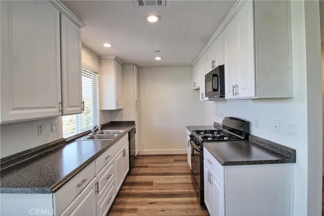 a kitchen with a sink a stove and cabinets