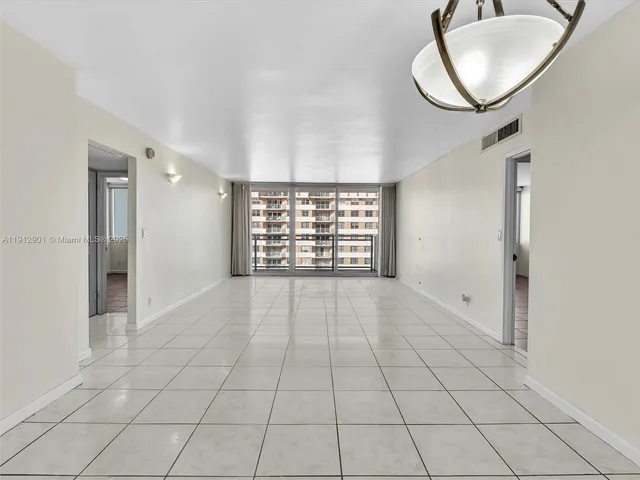 a view of an empty room with windows and cabinet