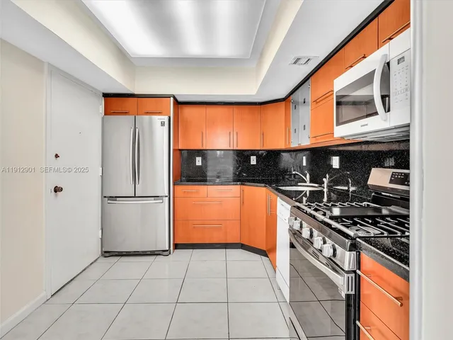 a kitchen with stainless steel appliances granite countertop a stove a sink and a refrigerator