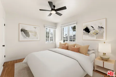 a bedroom with a large bed and a painting on the wall