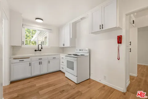 a kitchen with granite countertop white cabinets and white appliances