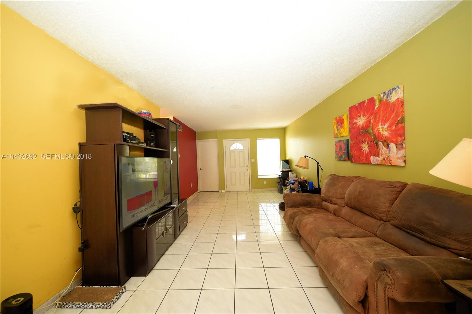 12193 Southwest 10th Street, Unit 1 Miami, FL 33184 - Photo 4 of 16 a living room with furniture and a flat screen tv