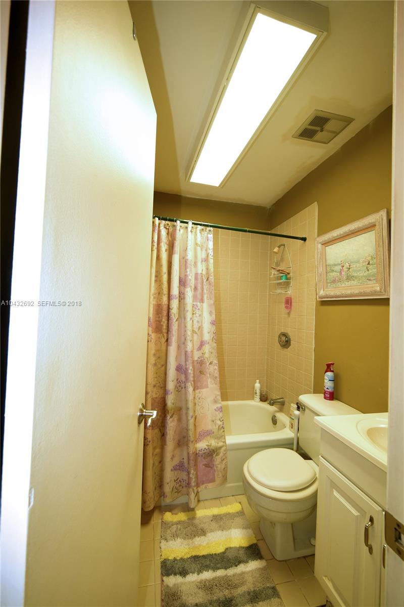 12193 Southwest 10th Street, Unit 1 Miami, FL 33184 - Photo 8 of 16 a bathroom with a toilet a sink and a bathtub