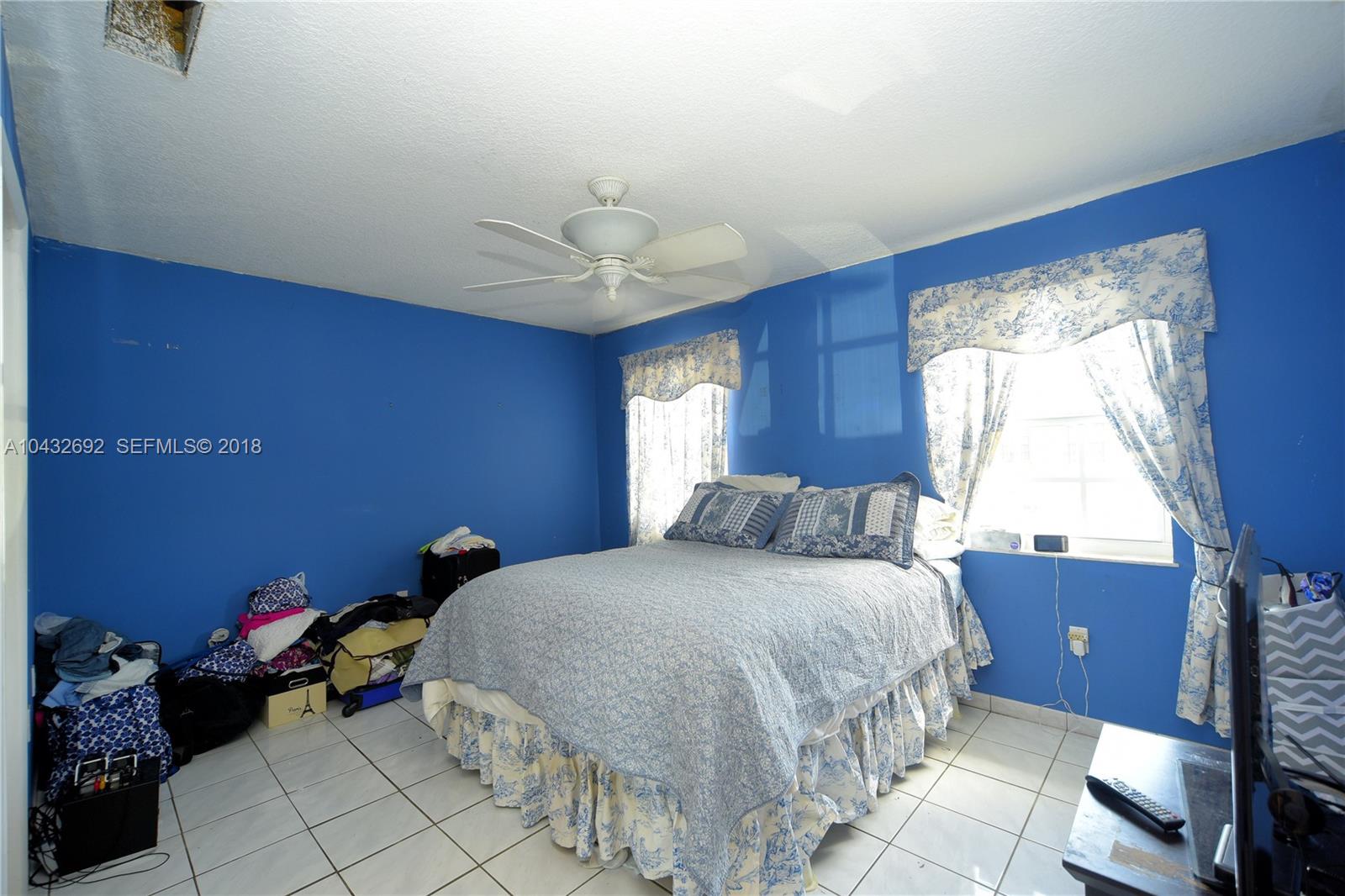 12193 Southwest 10th Street, Unit 1 Miami, FL 33184 - Photo 9 of 16 a bedroom with a bed and window
