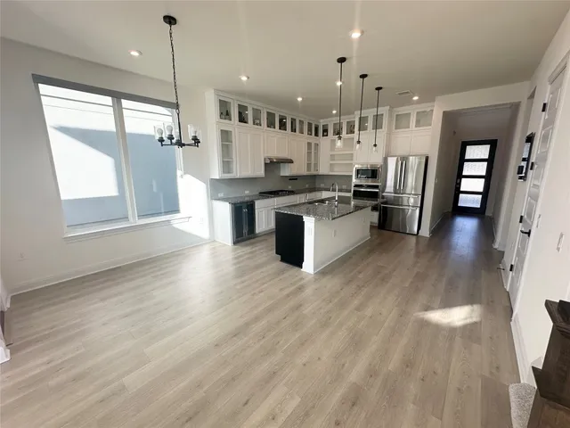 a large kitchen with lots of counter space wooden floor and stainless steel appliances