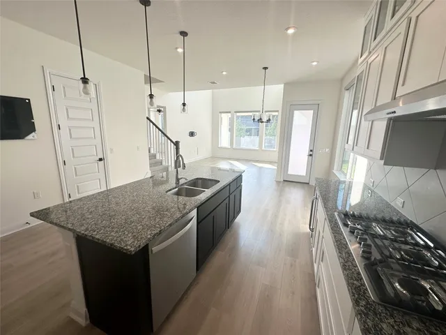 a kitchen with stainless steel appliances granite countertop a sink stove and refrigerator