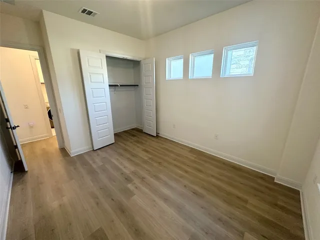 a view of empty room with wooden floor and window
