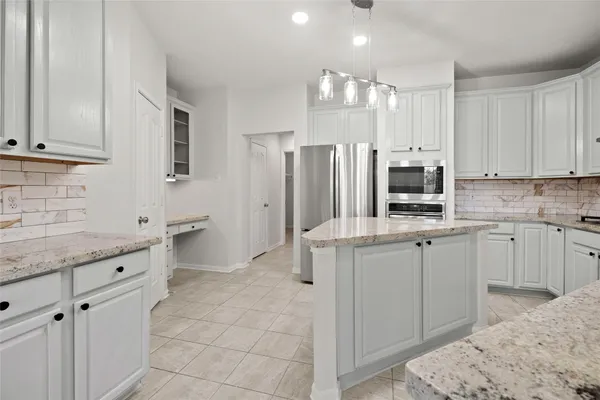 a large kitchen with kitchen island a sink stainless steel appliances and cabinets