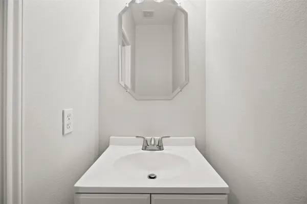 an empty room with wooden floor chandelier fan and windows