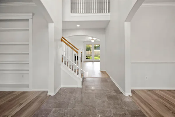 a view of a hallway with wooden floor and entryway