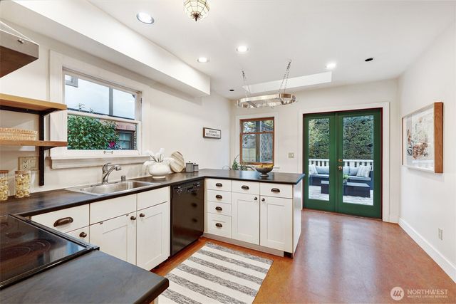 a large kitchen with stainless steel appliances granite countertop a sink and wooden floors