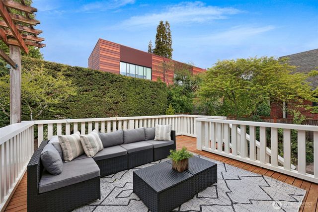 a balcony with wooden floor and outdoor seating