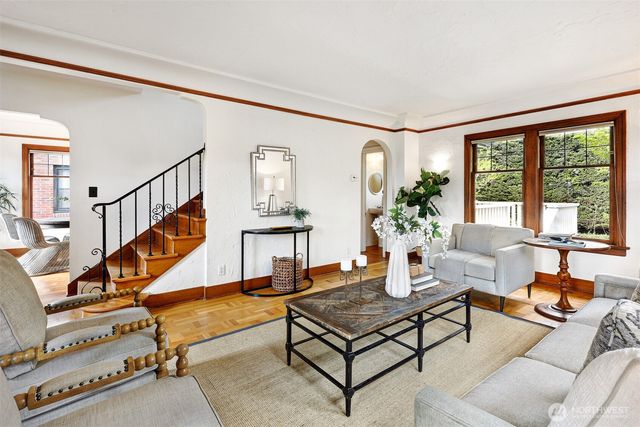 a living room with furniture stairs and a potted plant