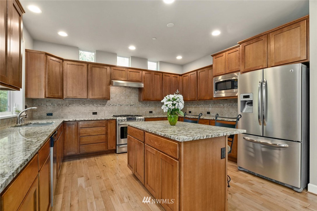 19622 94th Avenue Northeast, Unit 38 Bothell, WA 98011 - Photo 5 of 30 a kitchen with stainless steel appliances granite countertop a sink refrigerator and microwave
