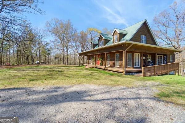 a view of a house with a yard and sitting area