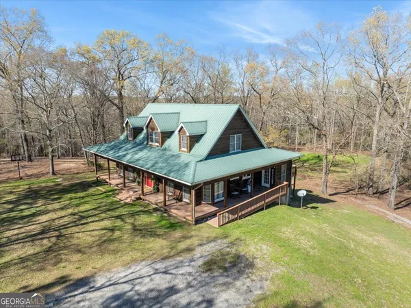 a view of a house with pool and a yard