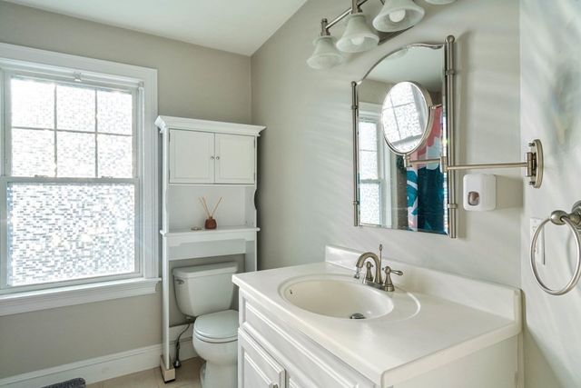 a bathroom with a sink a toilet and a mirror