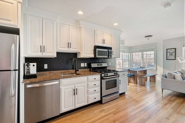 a kitchen with white cabinets and appliances