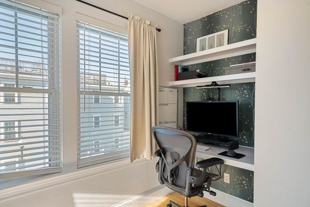 a view of a workspace with furniture and a window
