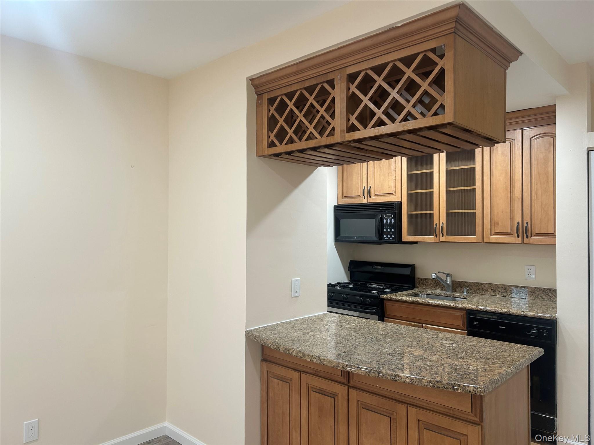 310 Riverside Boulevard, Unit 2C Long Beach, NY 11561 - Photo 11 of 21 a kitchen with a stove and a microwave