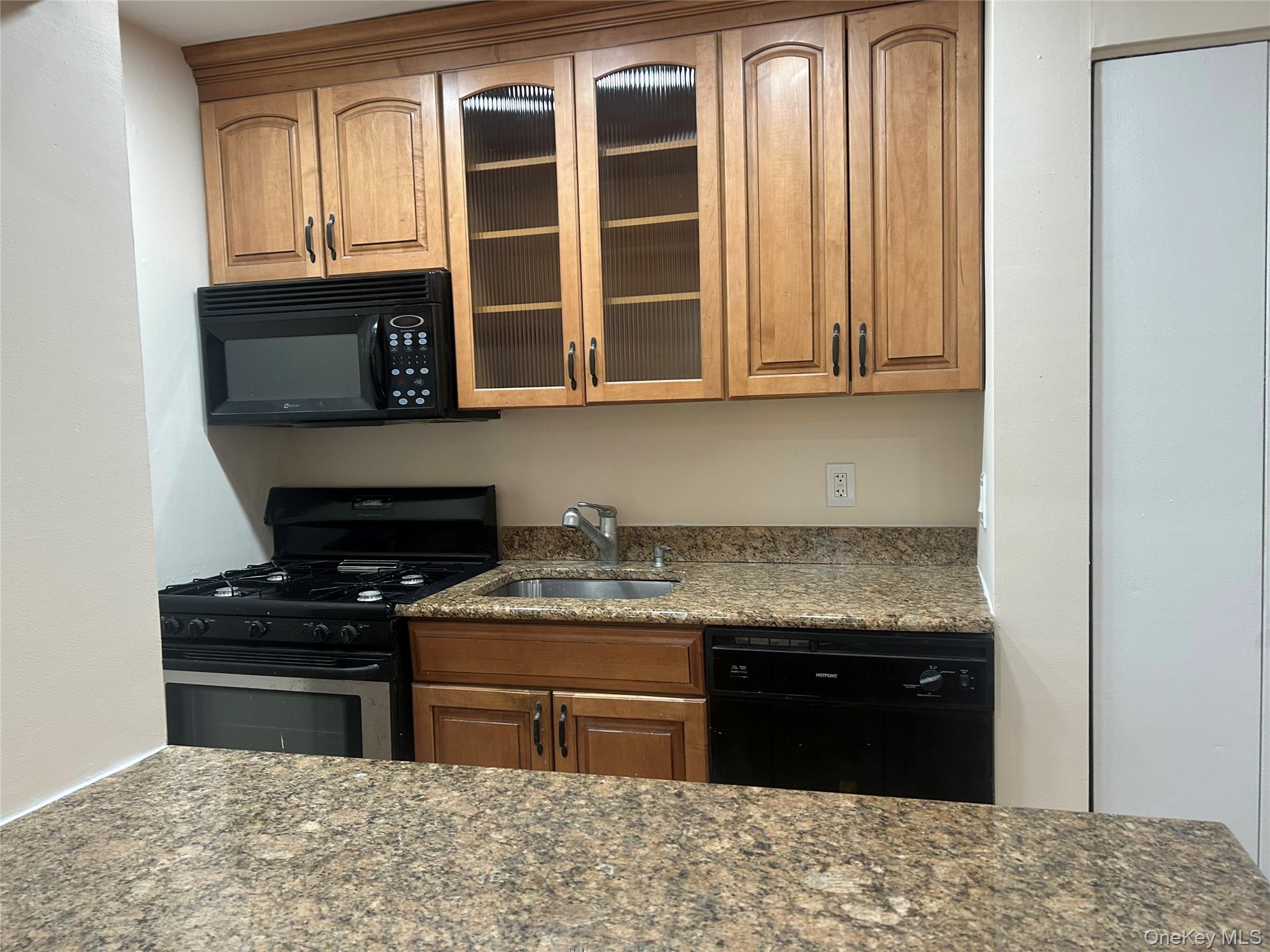 310 Riverside Boulevard, Unit 2C Long Beach, NY 11561 - Photo 12 of 21 a kitchen with stainless steel appliances granite countertop a stove and a cabinet