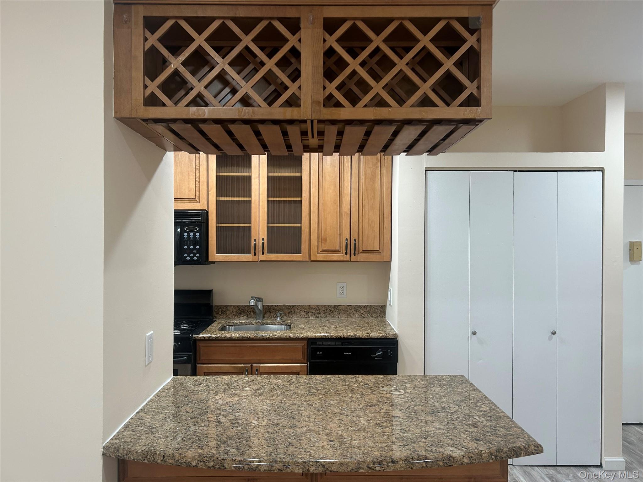 310 Riverside Boulevard, Unit 2C Long Beach, NY 11561 - Photo 13 of 21 a kitchen with a sink and a mirror