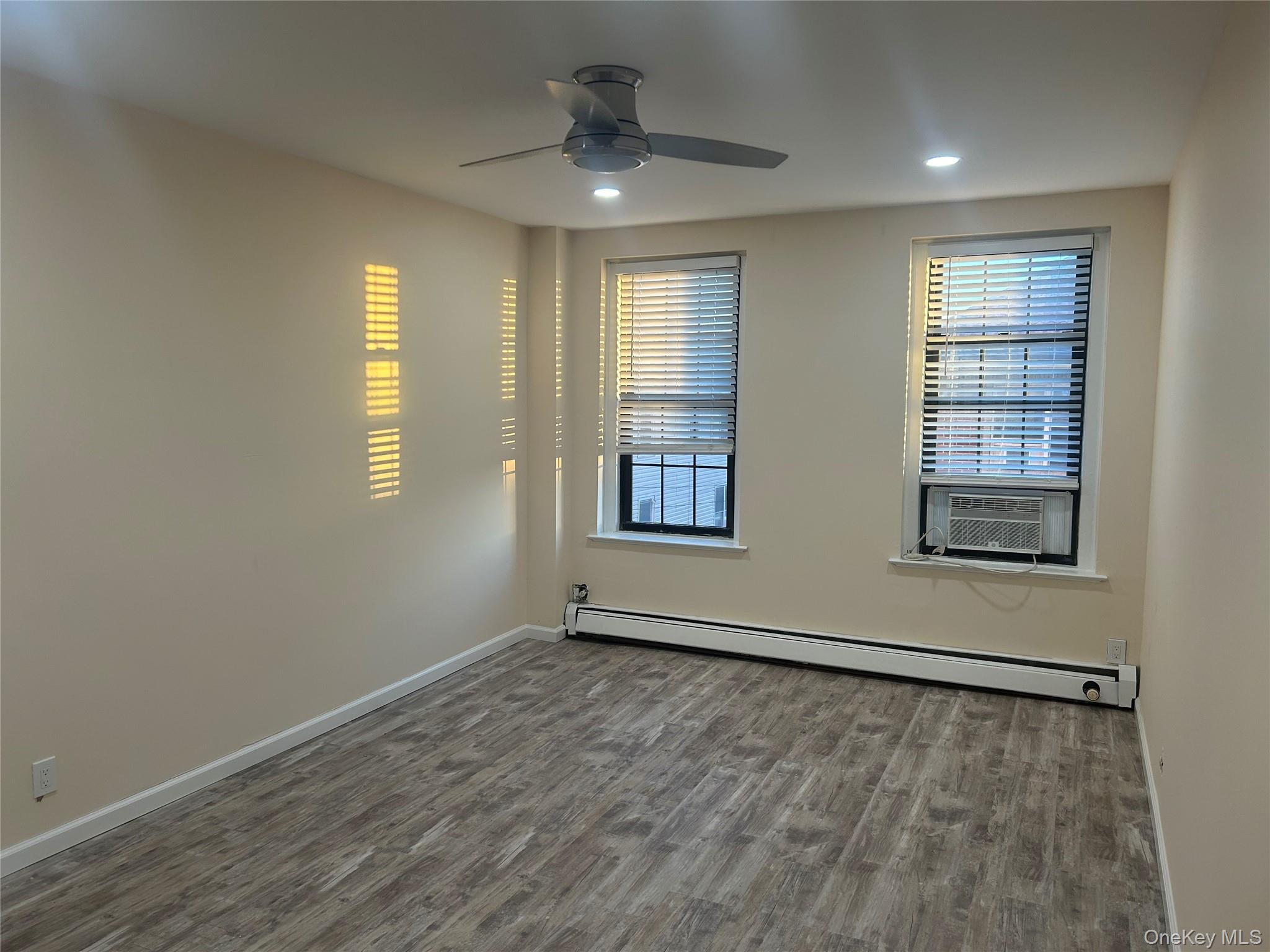 310 Riverside Boulevard, Unit 2C Long Beach, NY 11561 - Photo 18 of 21 an empty room with wooden floor and windows