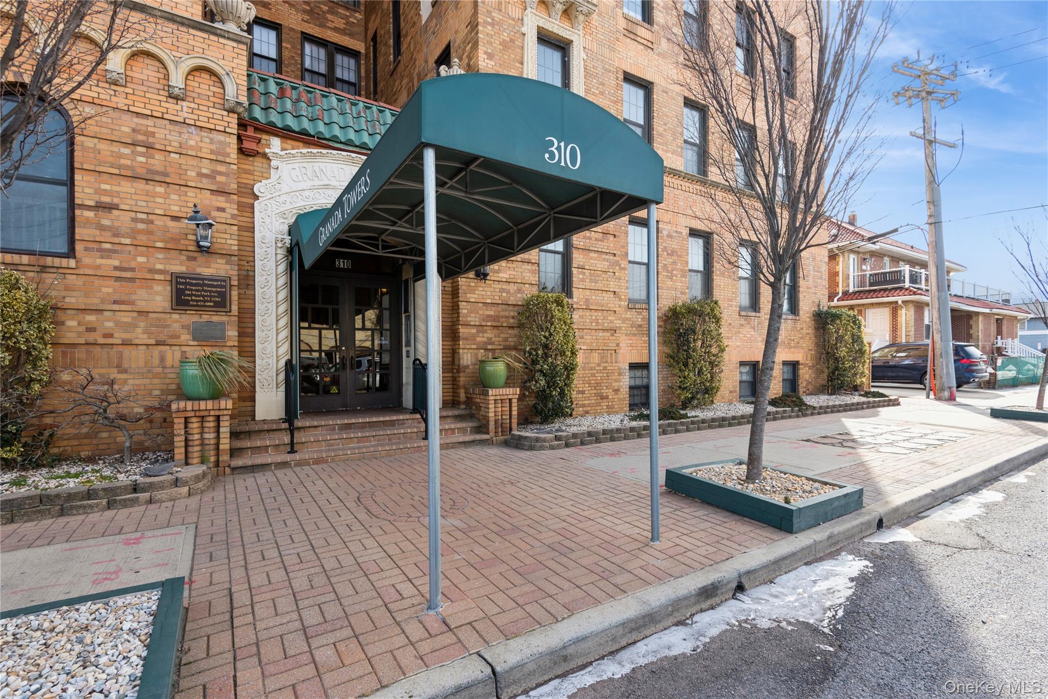 310 Riverside Boulevard, Unit 2C Long Beach, NY 11561 - Photo 3 of 21 a view of a patio with a table and chairs under an umbrella