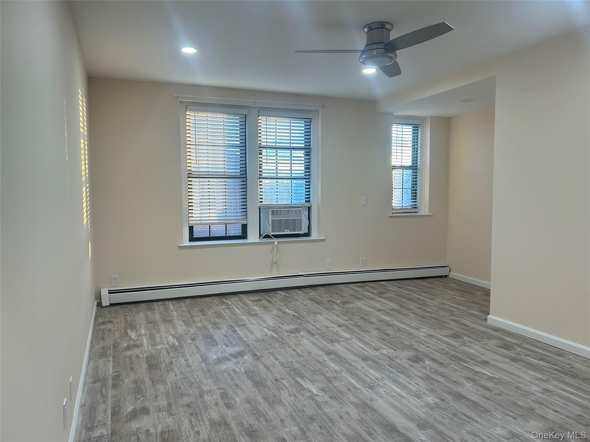 310 Riverside Boulevard, Unit 2C Long Beach, NY 11561 - Photo 6 of 21 an empty room with wooden floor and windows