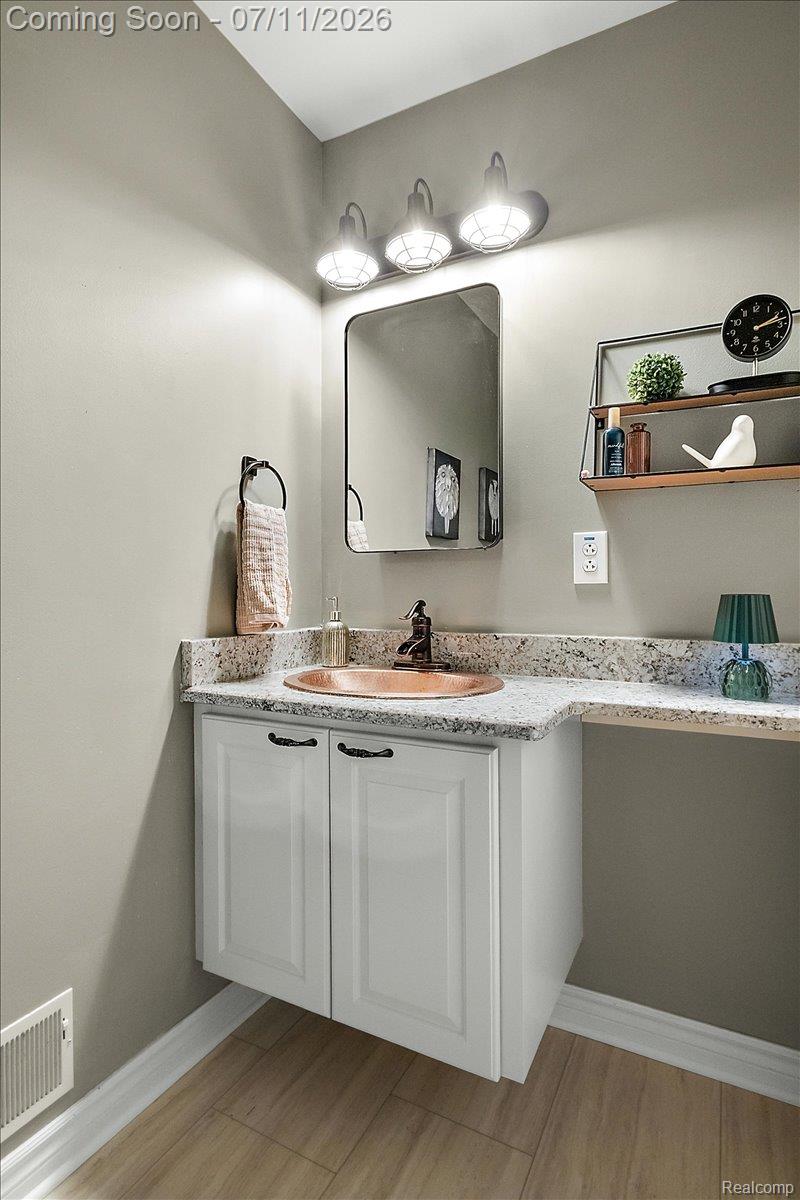 4219 Gardner Road Metamora, MI 48455 - Photo 31 of 87 Wall-mounted white vanity with a copper sink, stone countertop, and black fixtures