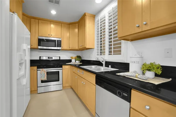 a kitchen with stainless steel appliances granite countertop a sink stove and microwave