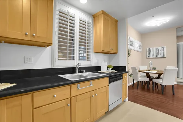 a kitchen with granite countertop a sink a stove a cabinets and a window