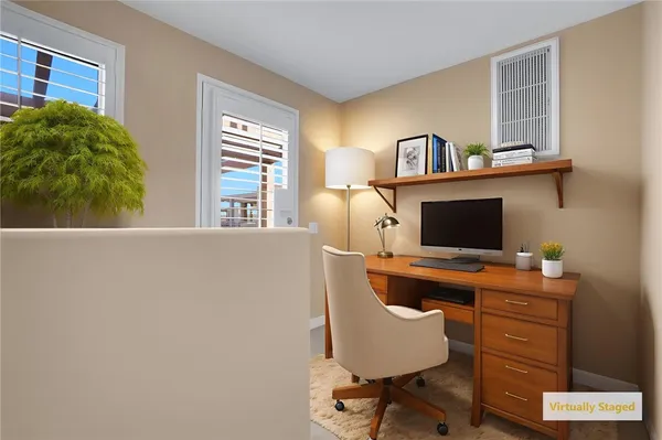 a view of a workspace with furniture and a window
