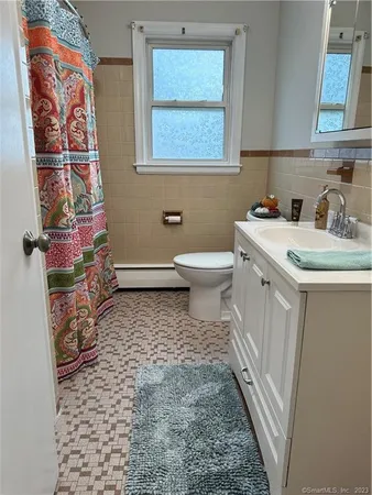 a bathroom with a sink a toilet and a window