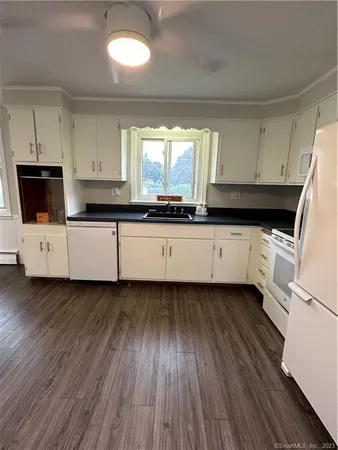 a kitchen with granite countertop a sink and a stove top oven