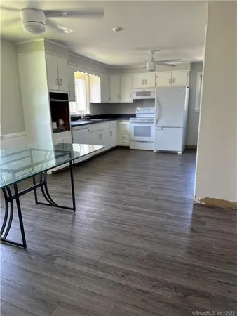 a living room with kitchen island granite countertop wooden floor and a fireplace