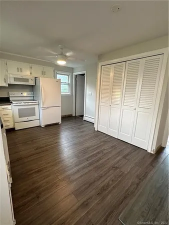 a view of kitchen with wooden floor and electronic appliances