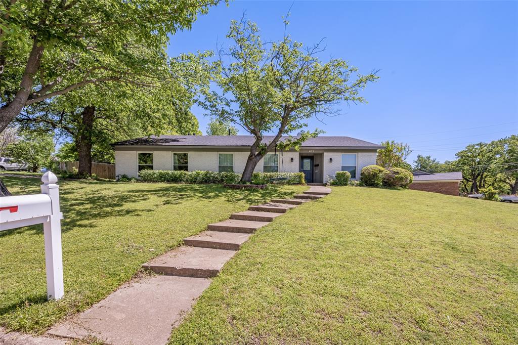625 Caduceus Lane Hurst, TX 76053 - Photo 1 of 21 a front view of a house with a yard table and chairs