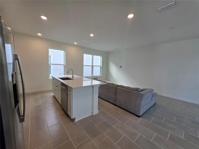 a kitchen with stainless steel appliances granite countertop a large counter top a refrigerator and a sink