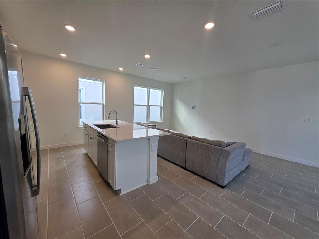2047 Iorio Street St. Cloud, FL 34771 - Photo 4 of 17 a kitchen with stainless steel appliances granite countertop a large counter top a refrigerator and a sink