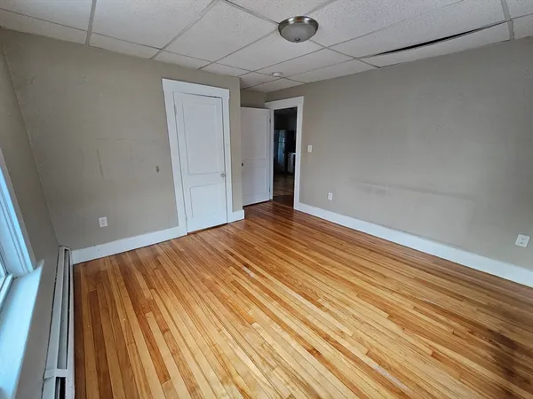a view of an empty room with wooden floor